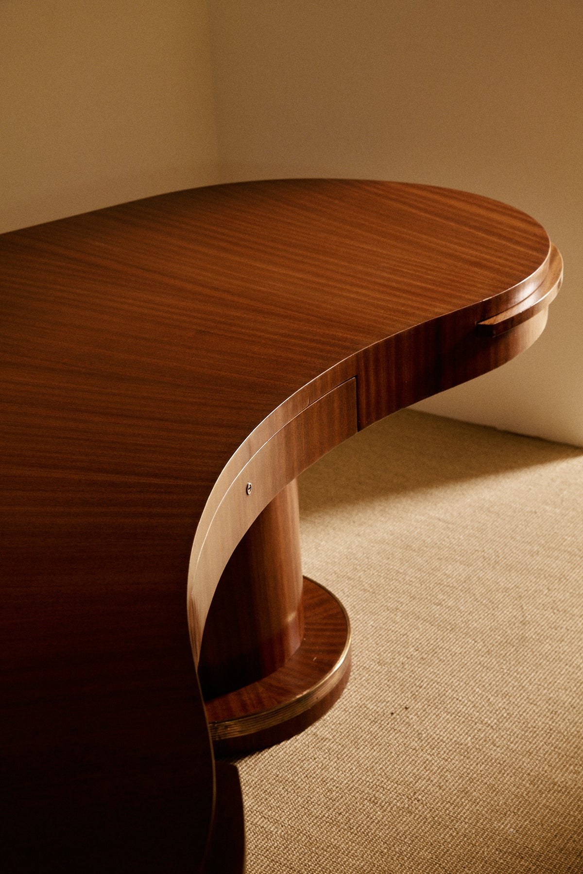 French Art Deco brass and rosewood desk, close-up of the curved end and pedestal base