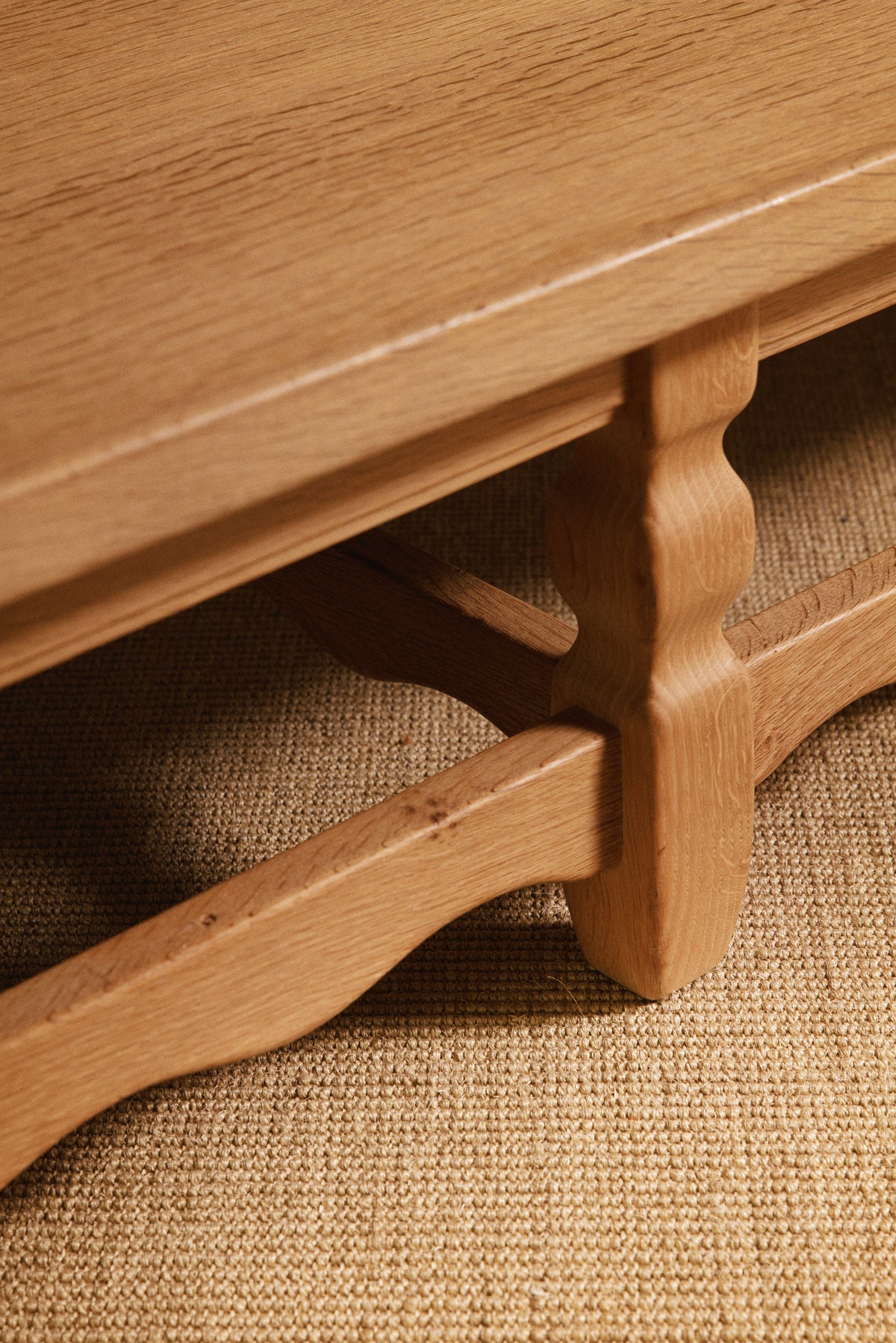 Henning Kjaernulf brushed oak coffee table, close view of a leg, the stretcher and the oak top edge