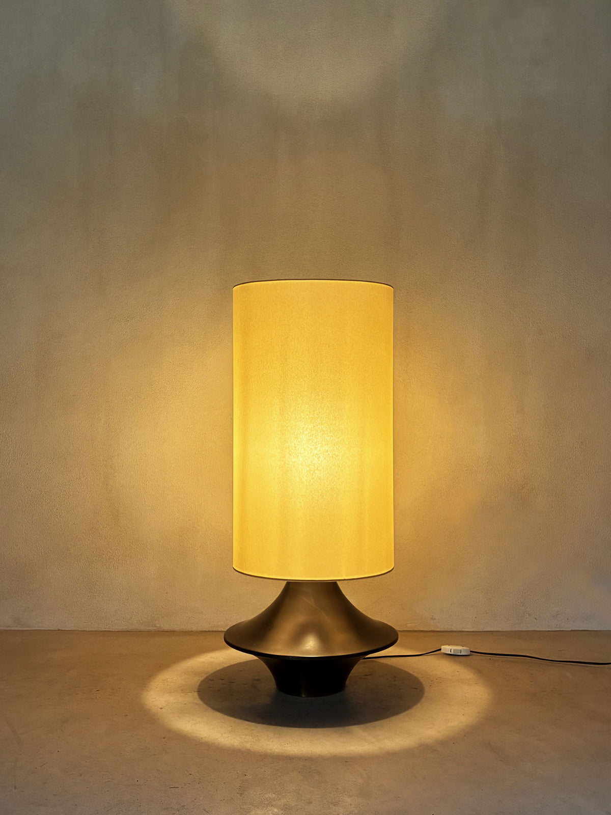 bronze lamp with parchment shade, lit, the parchment shade glowing