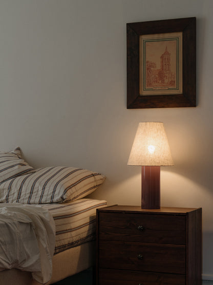 Giro Table Lamp in Bois de Rose, on a bedside chest, lit