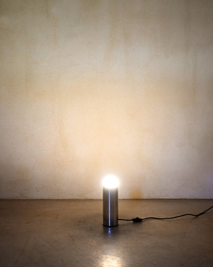 Enrico Tronconi chrome table lamps, pair, a single lamp lit, casting light on the floor and wall