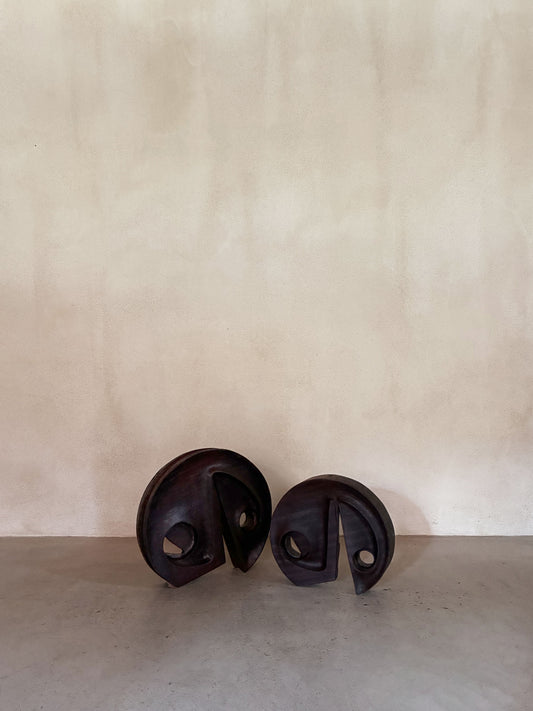 Gianni Pinna carved padouk wood sculpture, the pair of sculptures on the floor against a plaster wall
