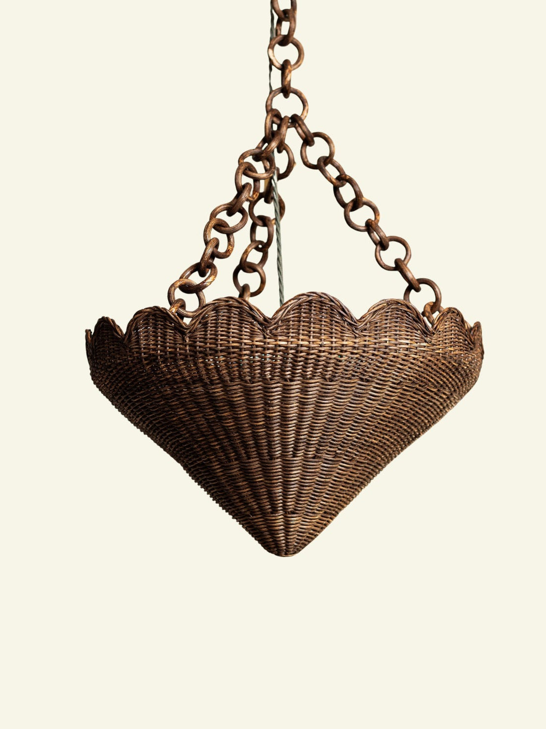 Primrose Rattan Pendant Shade, front view on a plain ground, hanging from its rattan chain