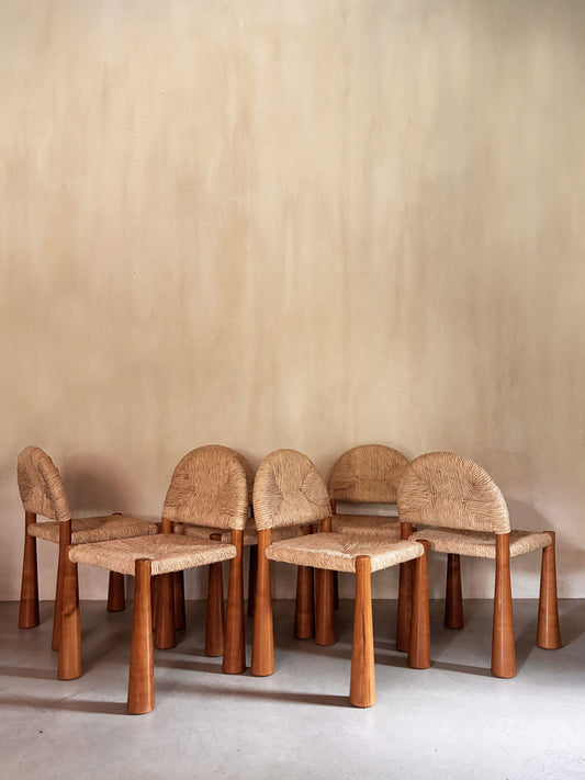Alessandro Becchi "Toscanolla" dining chair for Giovannetti, all six chairs grouped against a plaster wall