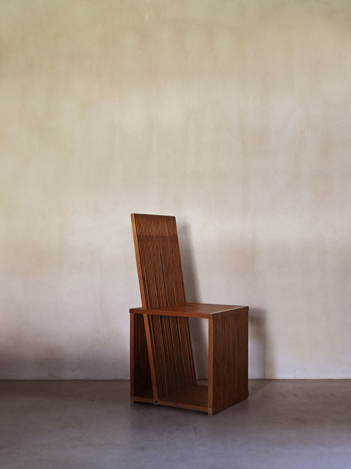 Brutalist wood Strips occasional chair, seen in profile, showing the tall slatted back