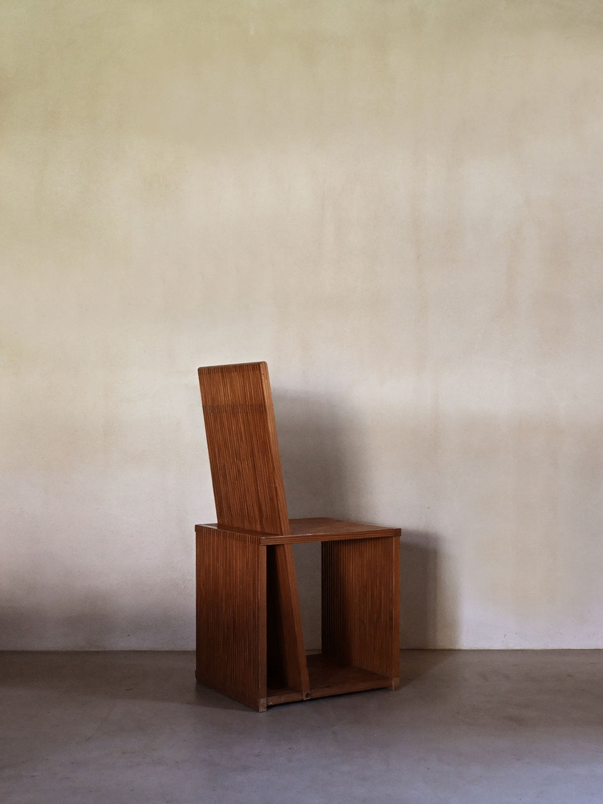 Brutalist wood Strips occasional chair, three-quarter view showing the slatted side panel and seat