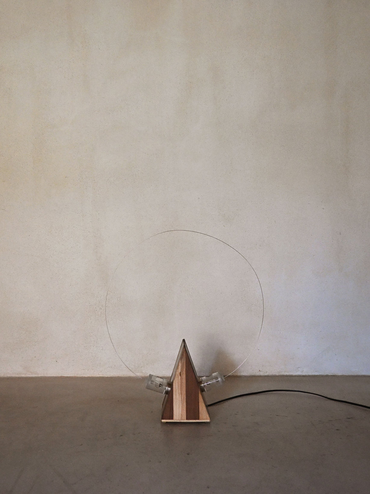 Studio A.R.D.I.T.I. "BT1972" lamp, unlit, wood body and exposed bulbs against a plaster wall