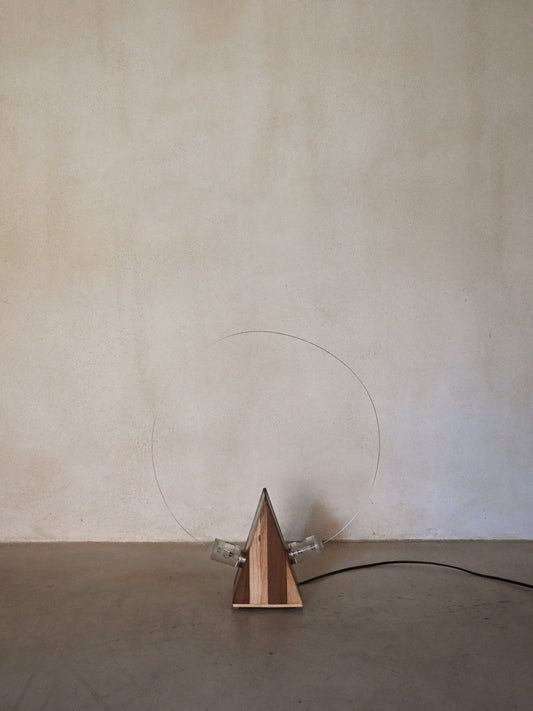 Studio A.R.D.I.T.I. "BT1972" lamp, unlit, wood body and exposed bulbs against a plaster wall