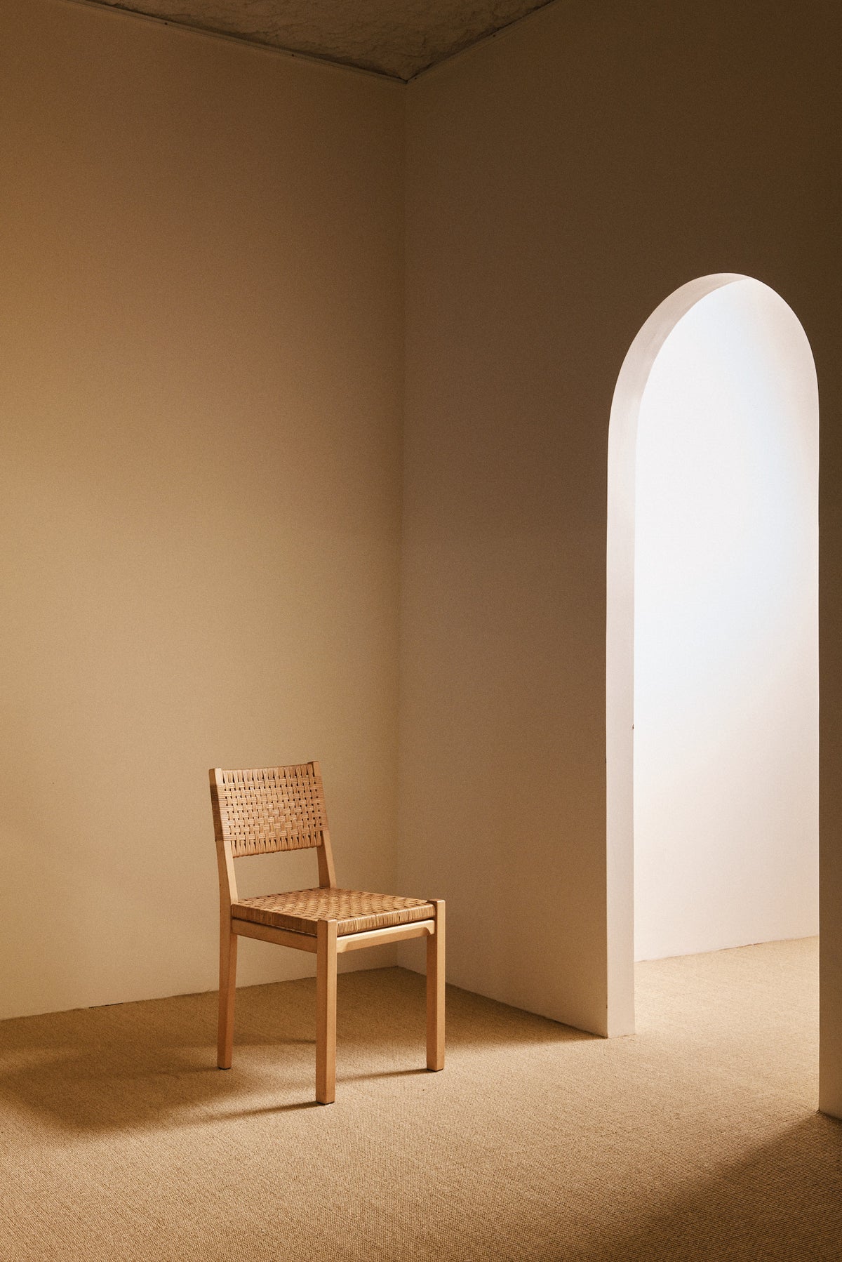 Aino Aalto birch and woven rattan 615 chairs, single chair beside the arched doorway