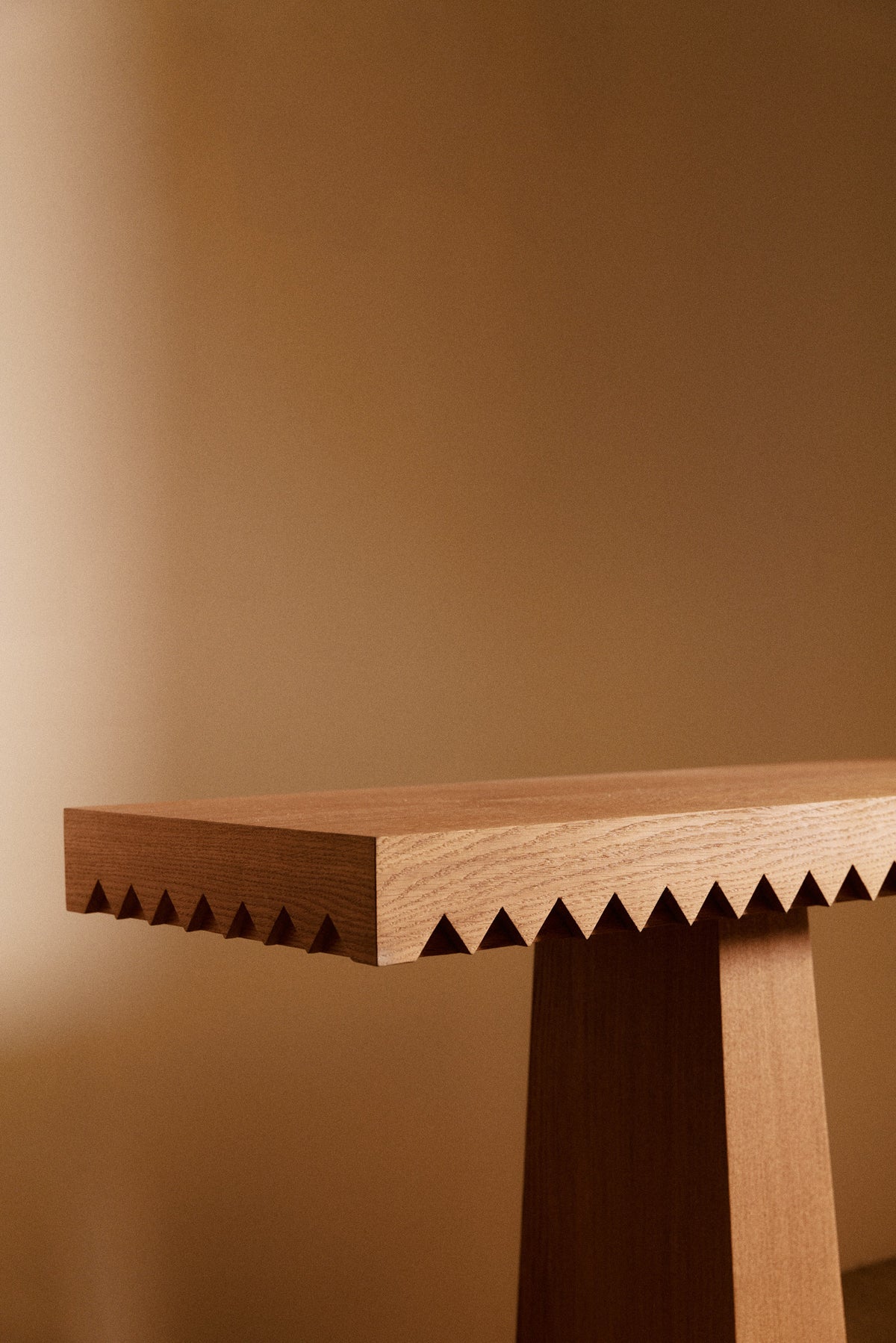 Baga oak console table, close view of the toothed edge and a leg