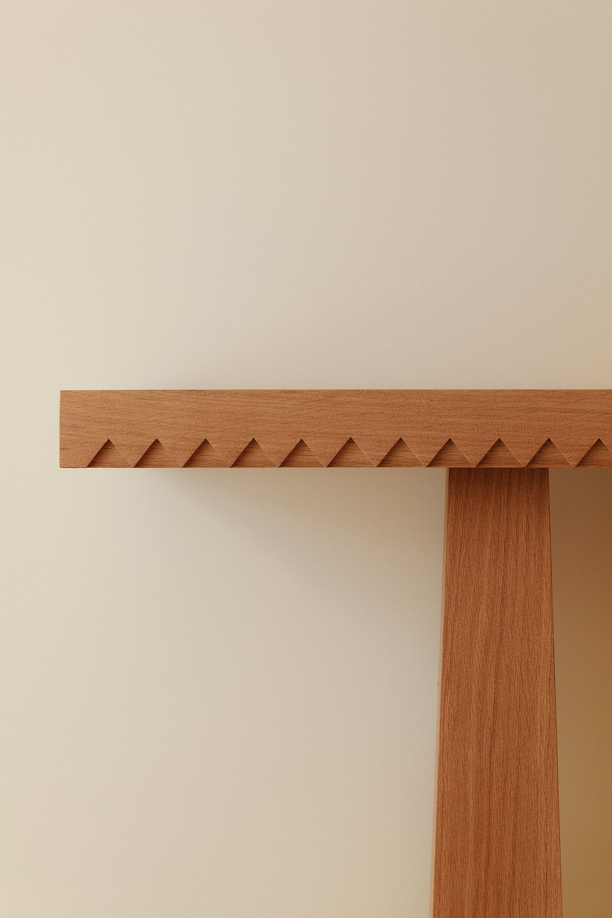 Baga oak console table, closer front view of a leg under the toothed top