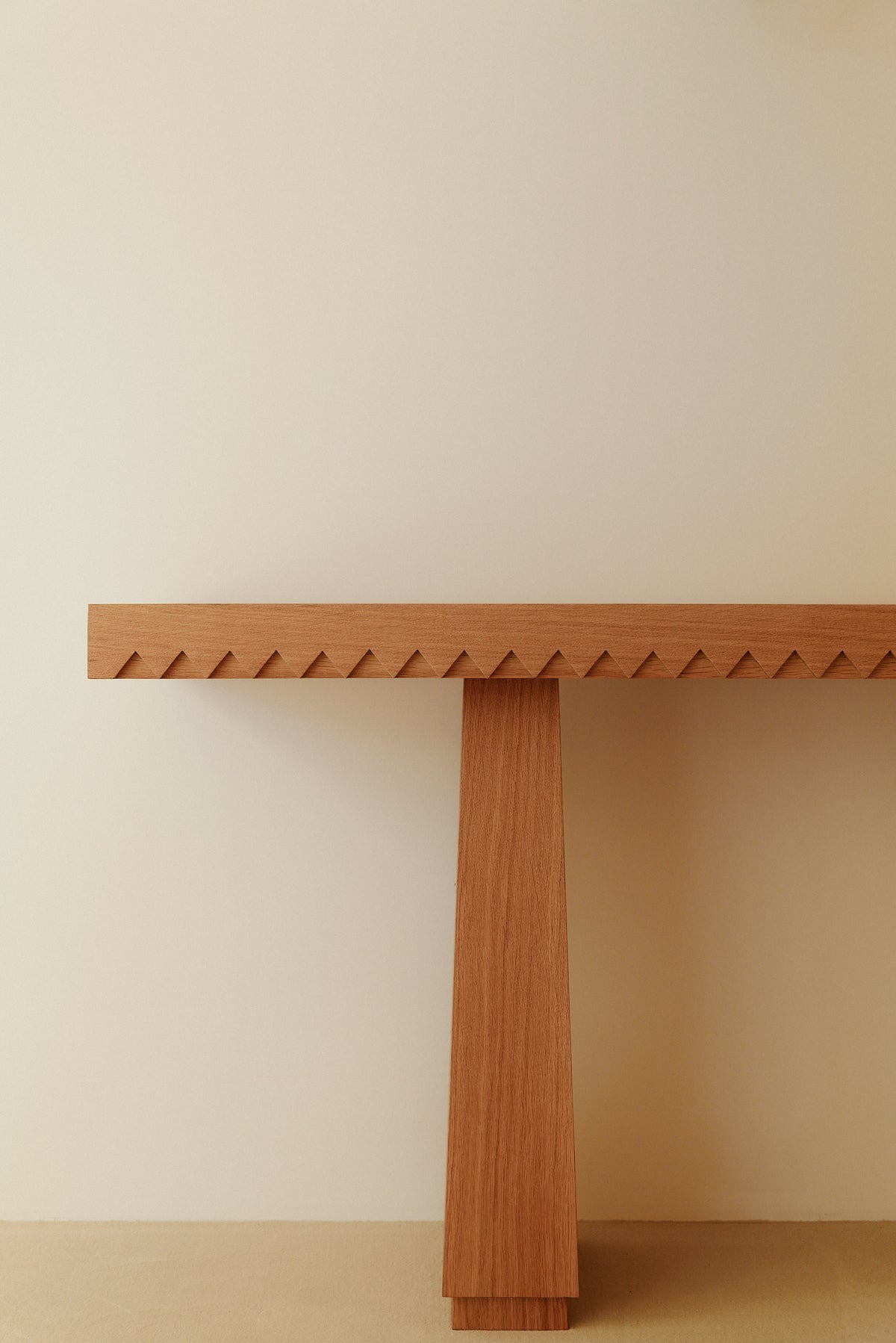 Baga oak console table, front view of a leg under the toothed top