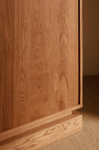 Cabinet 01 in solid oak, close view of the oak side and plinth