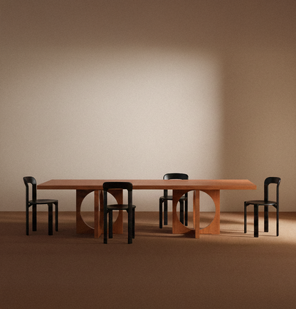 Moon dining table in solid oiled oak, front view with four black chairs around the table
