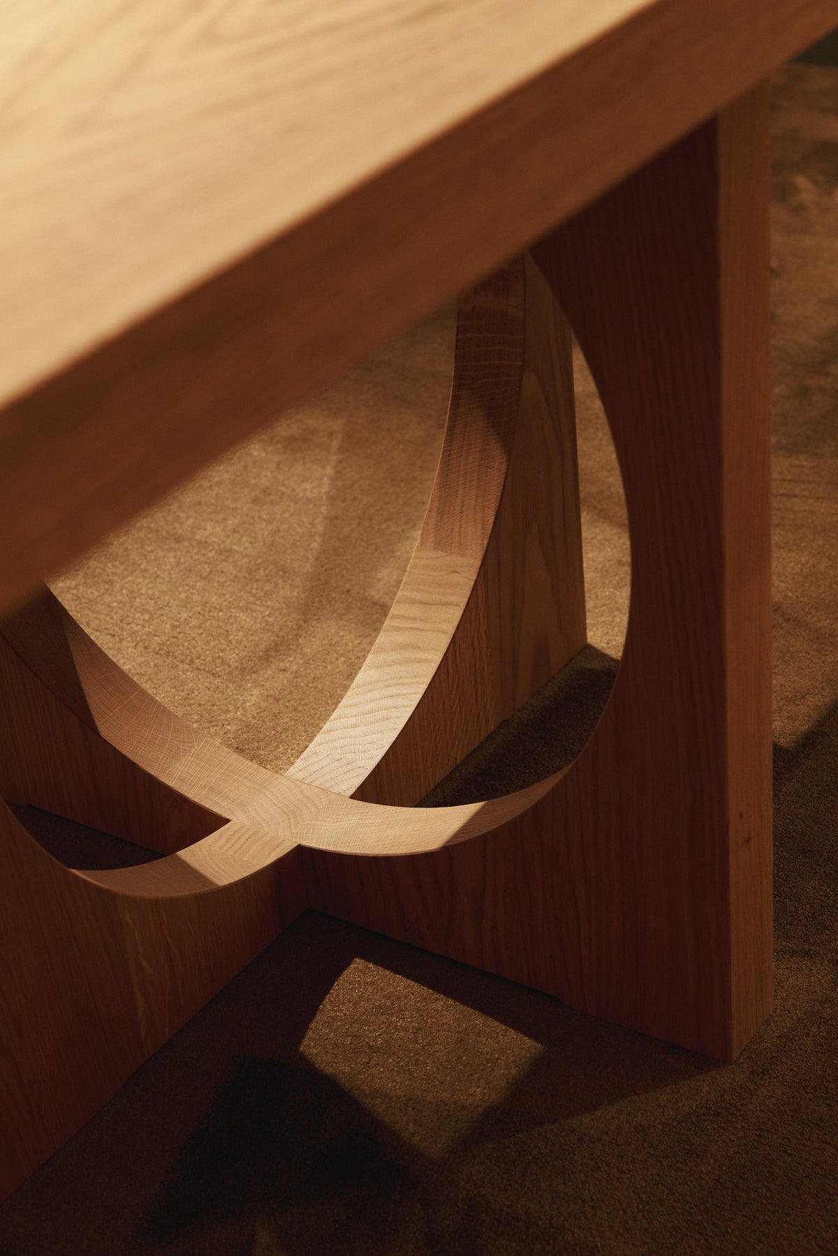 Moon dining table in solid oiled oak, nearer close view of the crossing oak bands inside a leg