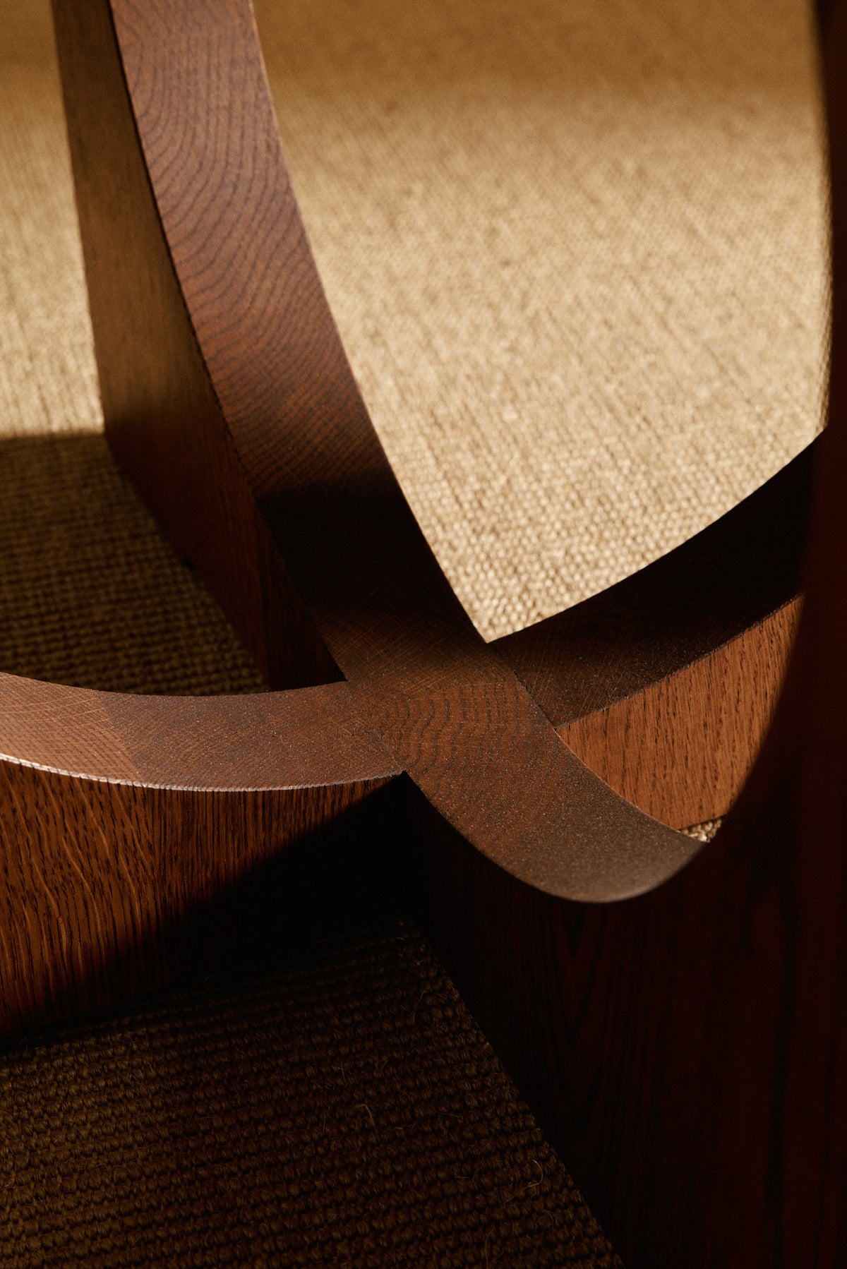 Moon Ronde round dining table in solid oiled oak, close view of the crossing oak bands inside a leg