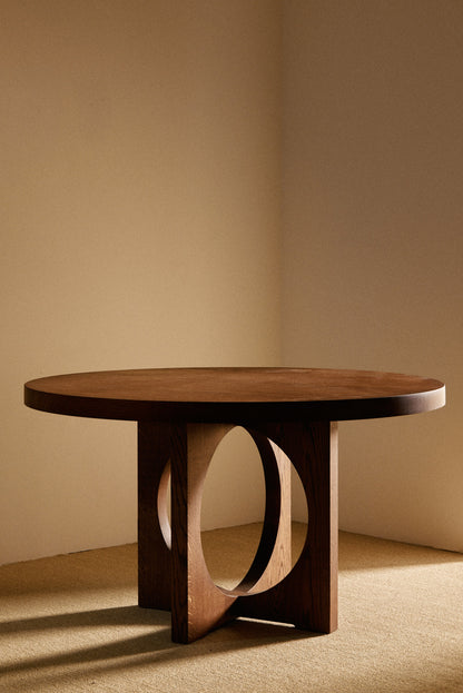 Moon Ronde round dining table in solid oiled oak, front view of the round table in the room