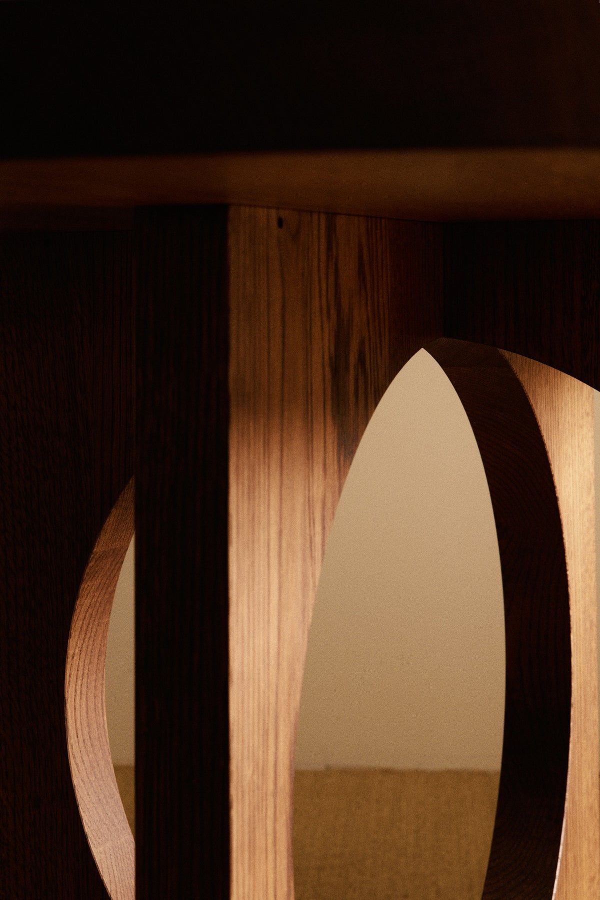Moon Ronde round dining table in solid oiled oak, close view of a leg edge and oval opening