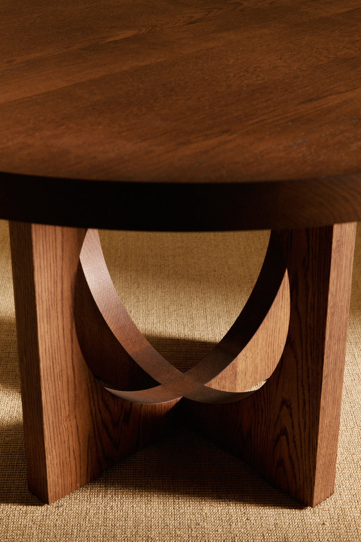 Moon Ronde round dining table in solid oiled oak, close view of the crossing bands under the top