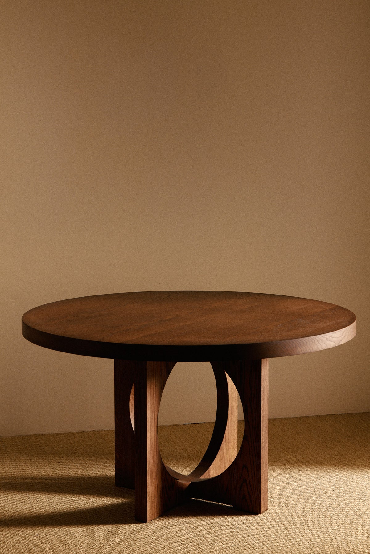 Moon Ronde round dining table in solid oiled oak, low front view of the legs and top