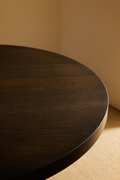 Orion round dining table in solid oiled oak, close view of the round top edge in a darker tone