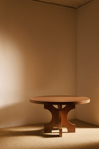 Orion round dining table in solid oiled oak, front view of the round table in the room