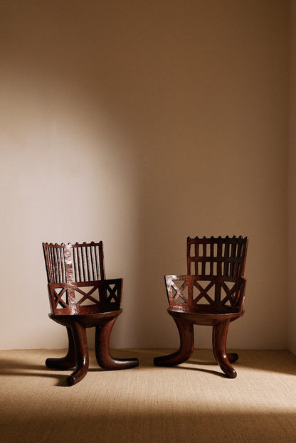 Ethiopian carved and openwork wood armchair, front view, the left chair is the one offered