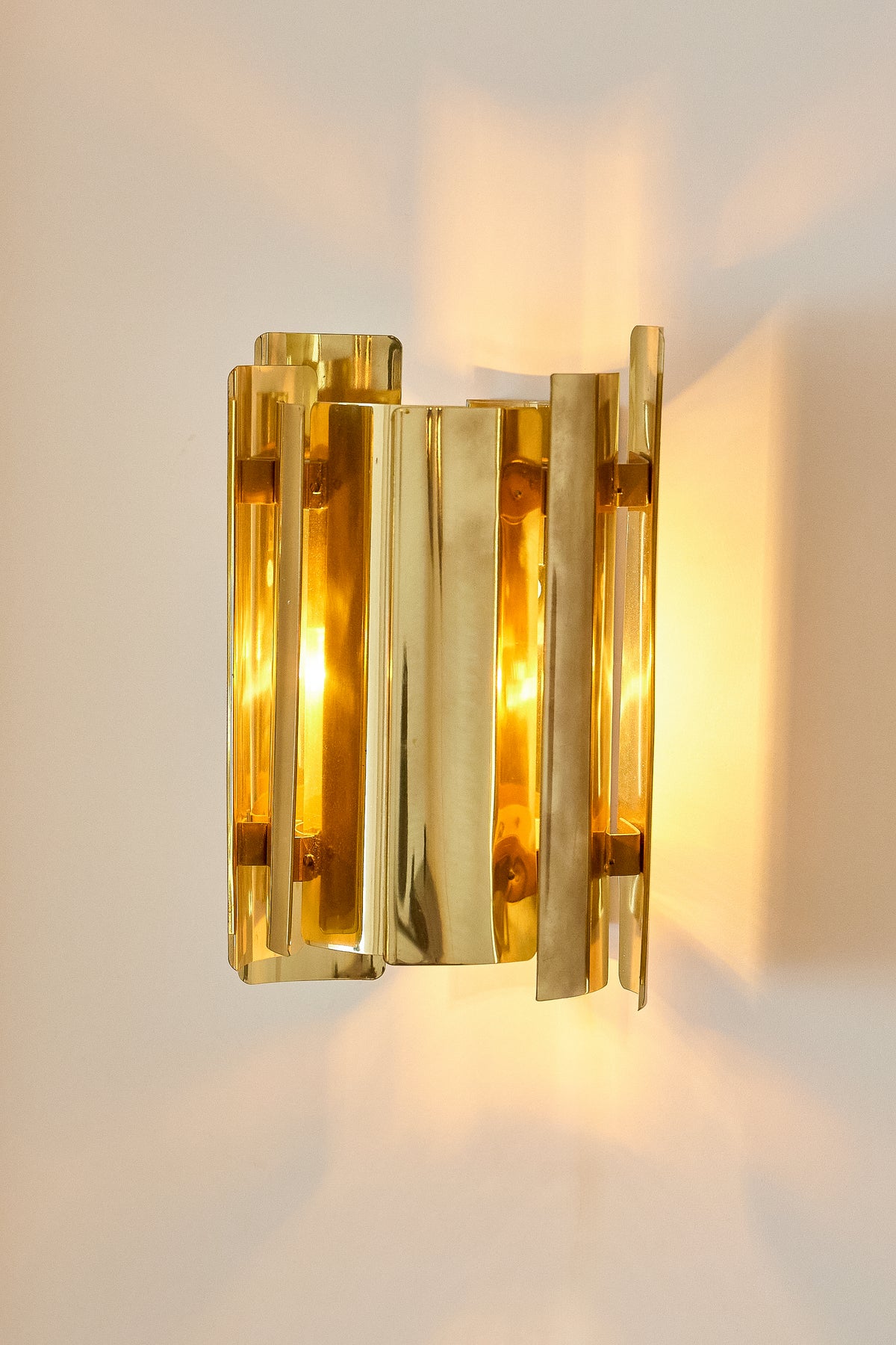 Falkenbergs Belysning brass sconce, nearer view of the lit sconce on the wall
