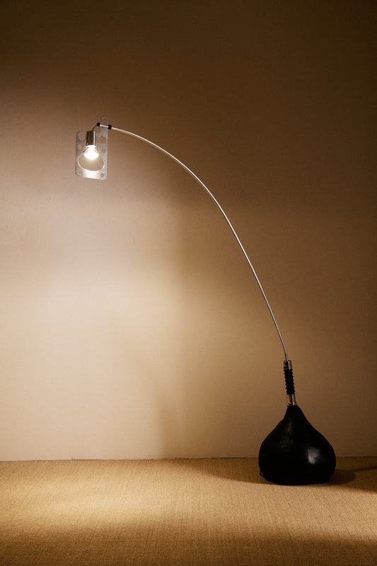 Gabetti & Isola leather and metal floor lamp, full view lit in the corner of the room