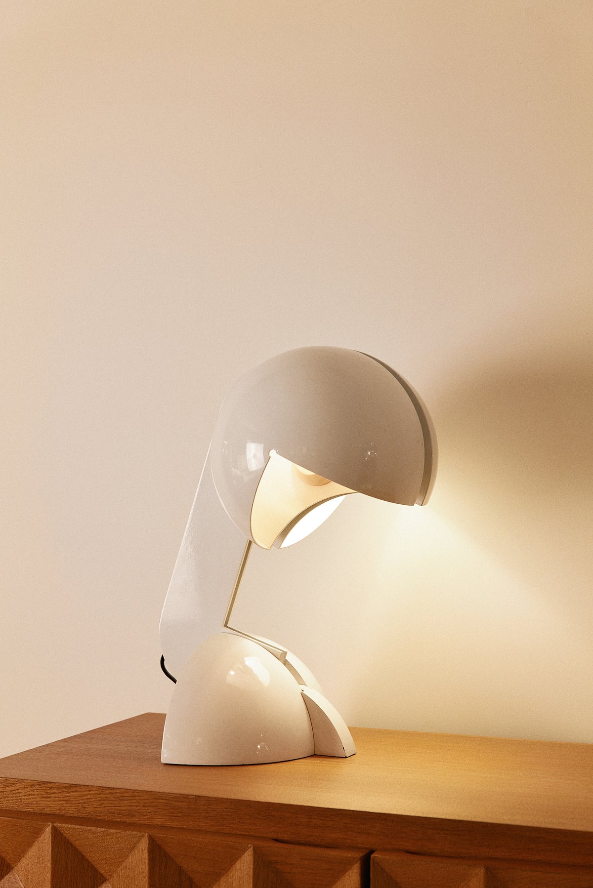 Gae Aulenti enameled aluminum Ruspa table lamp, angled view lit on a cabinet