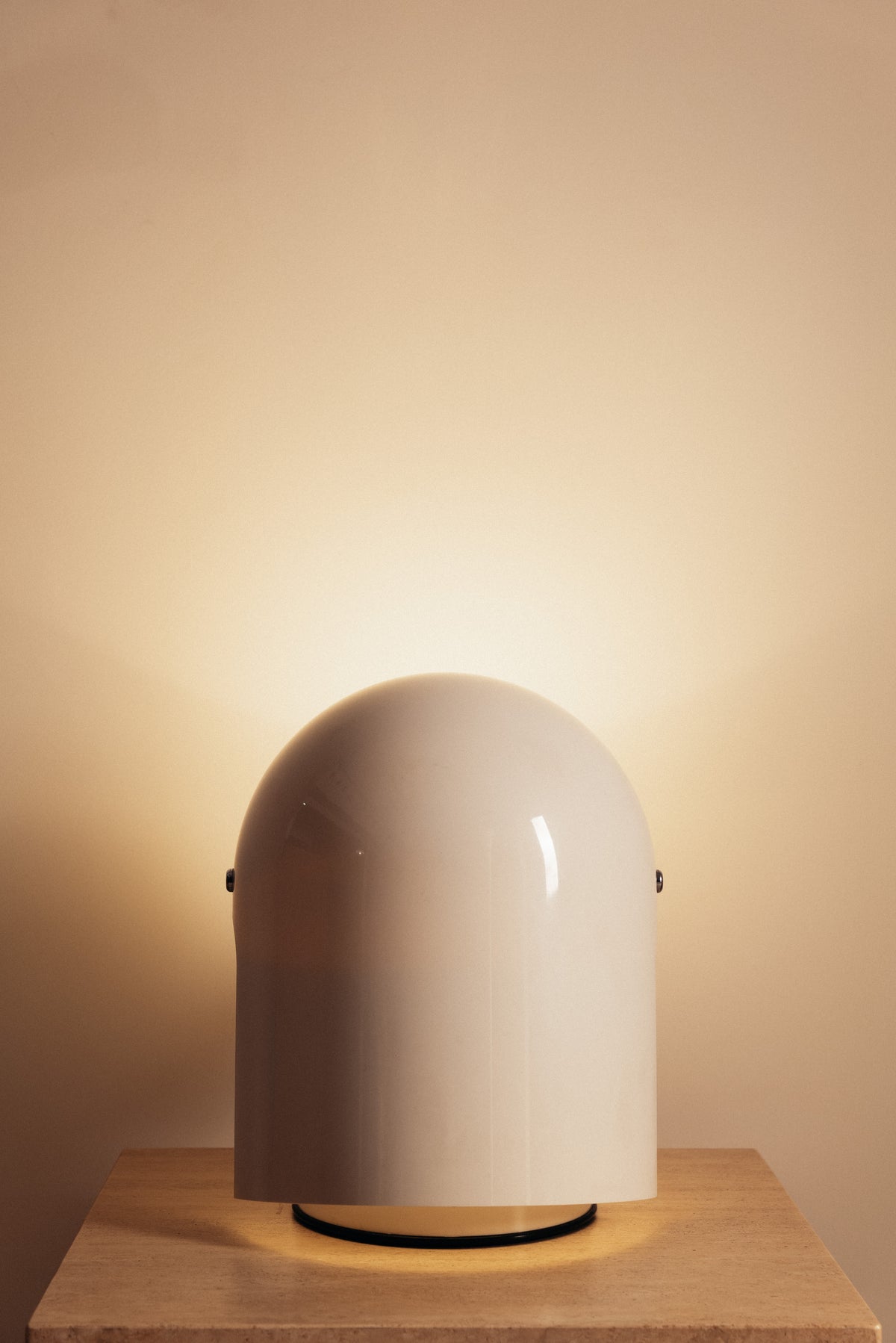 Gae Aulenti molded ABS Mezzo Pileo table lamp, hood closed, lit from below