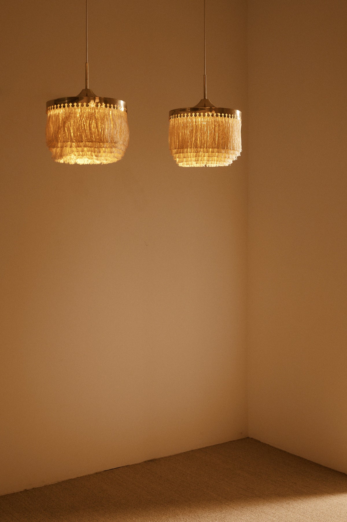 Hans Agne Jakobsson brass and silk pendant lights, pair hanging in the corner of the room