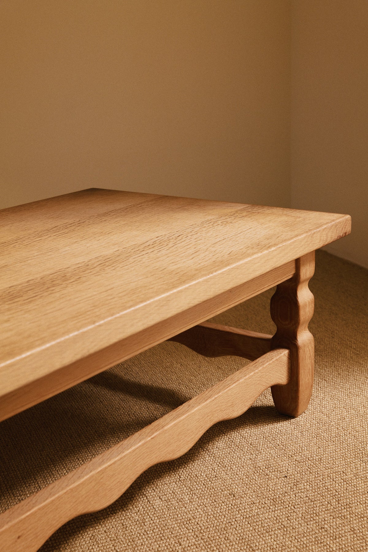 Henning Kjaernulf brushed oak coffee table, angled view of the corner, leg and wave cut stretcher
