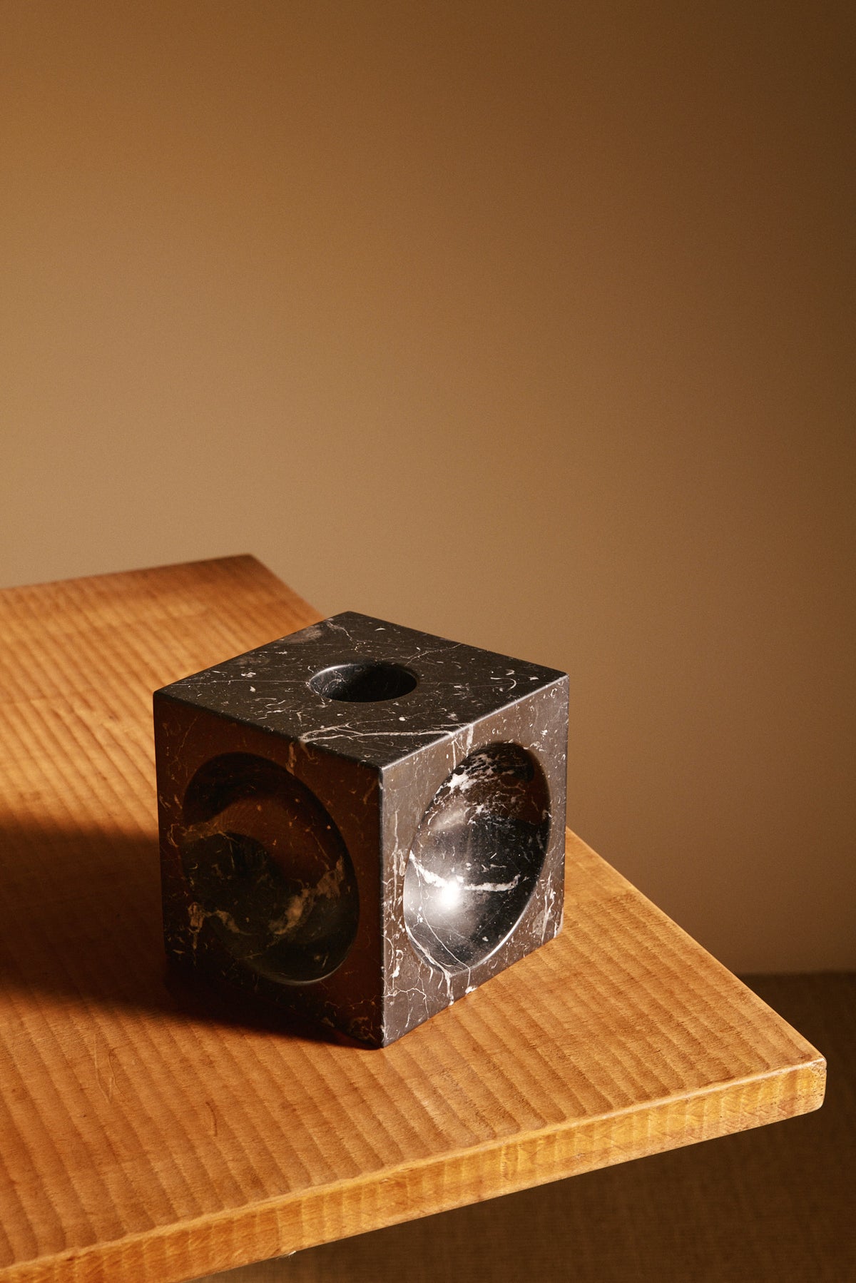 Italian black marble sculptural vase, angled view on a wooden table