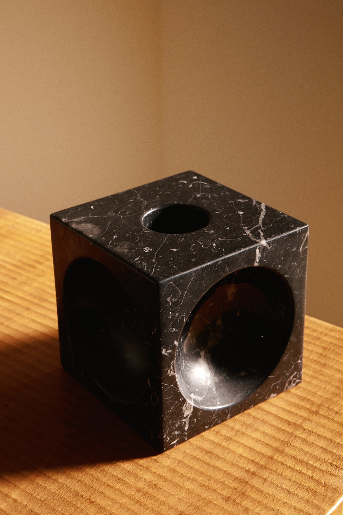 Italian black marble sculptural vase, close view of the round hollow, the top opening and the white veining