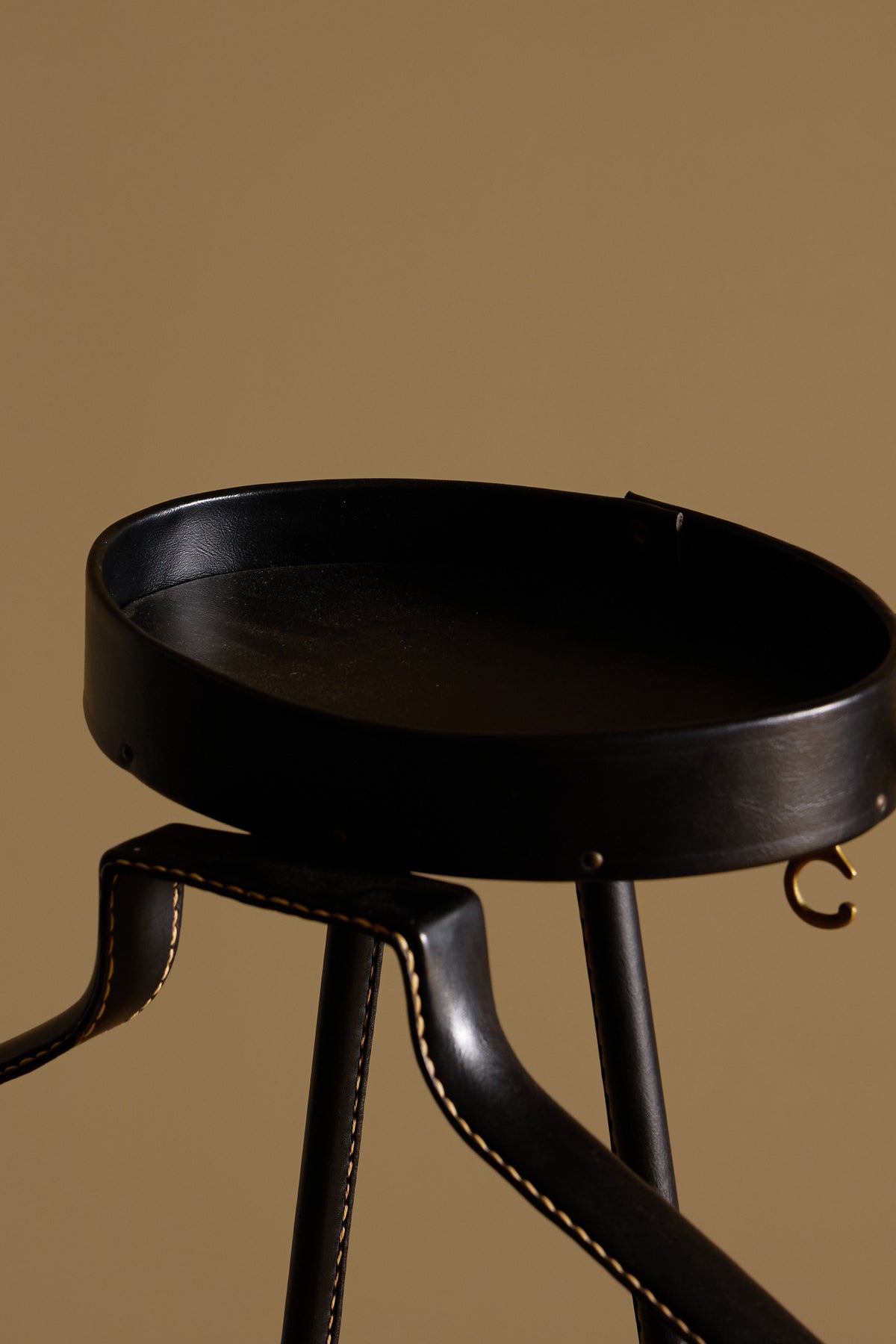 Jacques Adnet lacquered metal and leather night valet, close view of the round leather tray and stitched arm