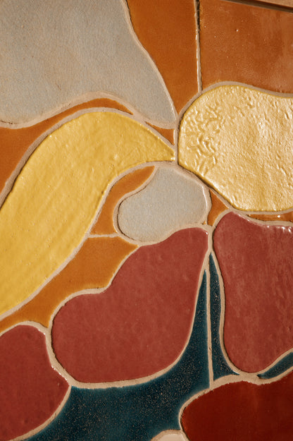 Jan Snoeck ceramic artwork in a wooden frame, close view of the yellow, rose and grey glazed shapes