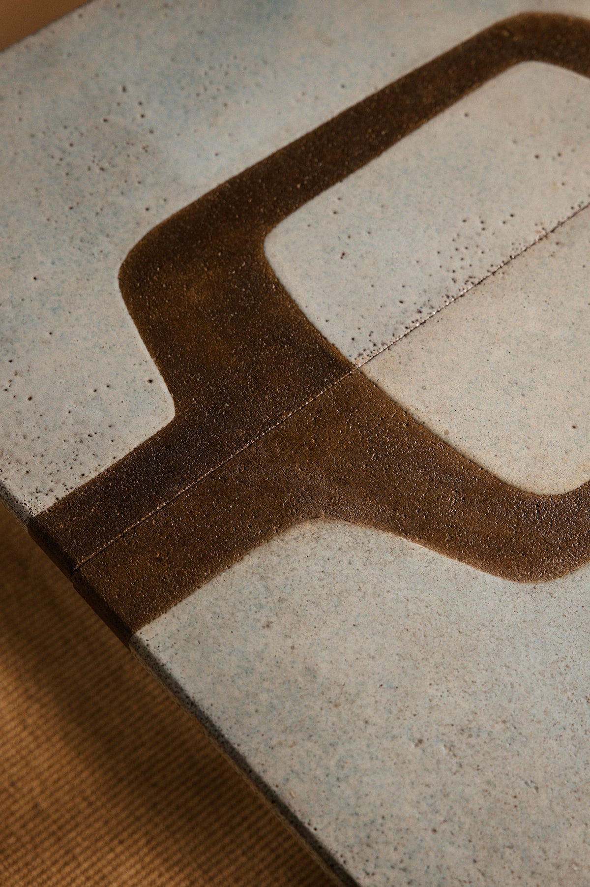 Les Deux Potiers teak wood and ceramic coffee table, close view of the dark inlay across the ceramic top