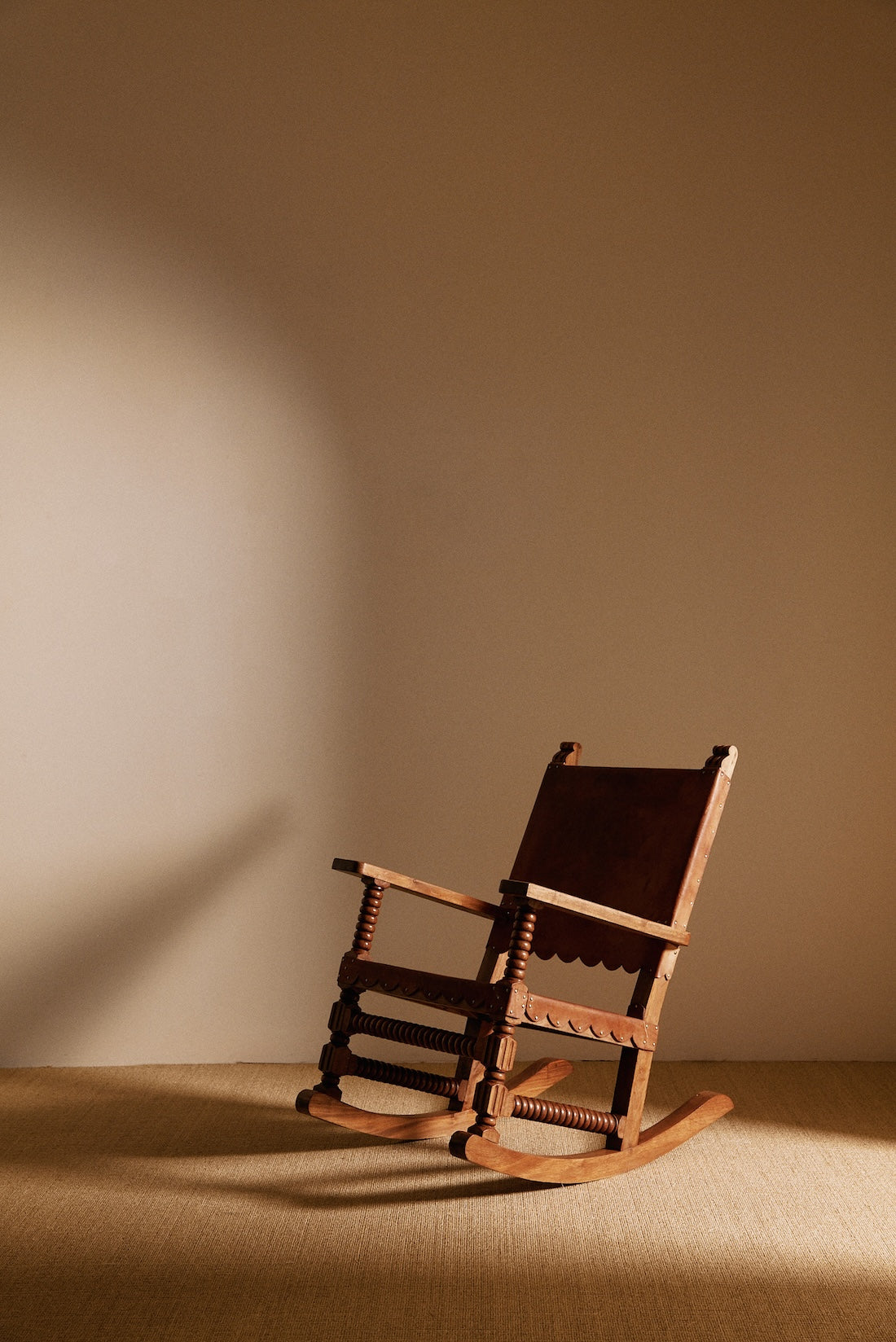 Mexican oak and tanned leather rocking chair, angled view