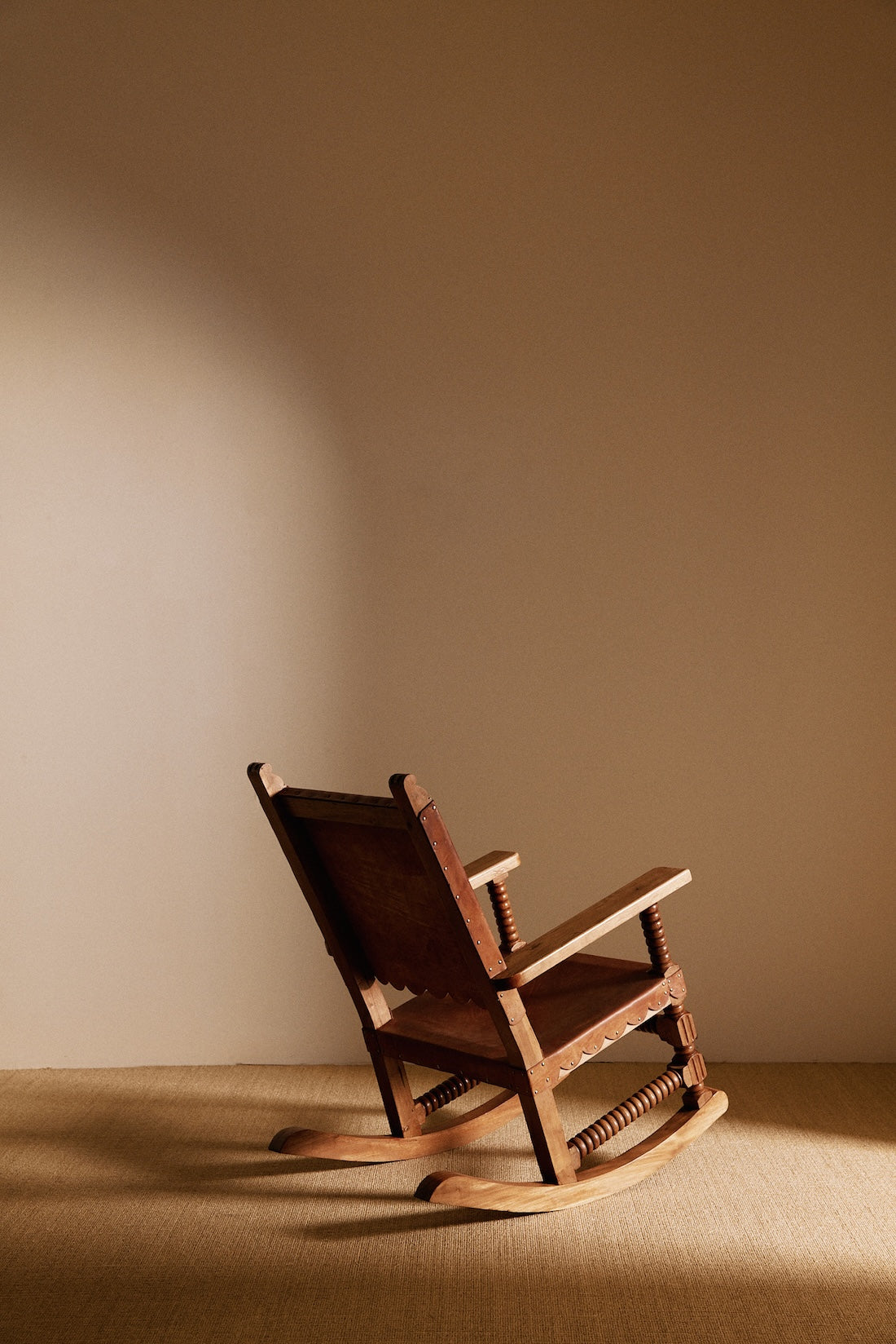 Mexican oak and tanned leather rocking chair, back angled view