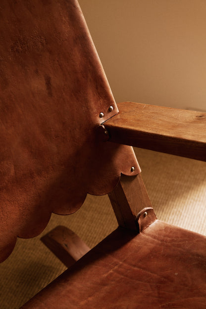 Mexican oak and tanned leather rocking chair, close-up of the leather back, scalloped edge and arm joint