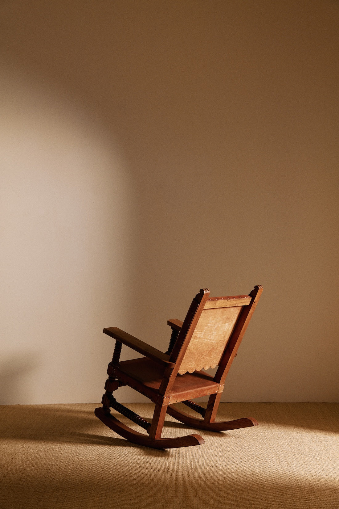 Mexican oak and tanned leather rocking chair, rear three-quarter view