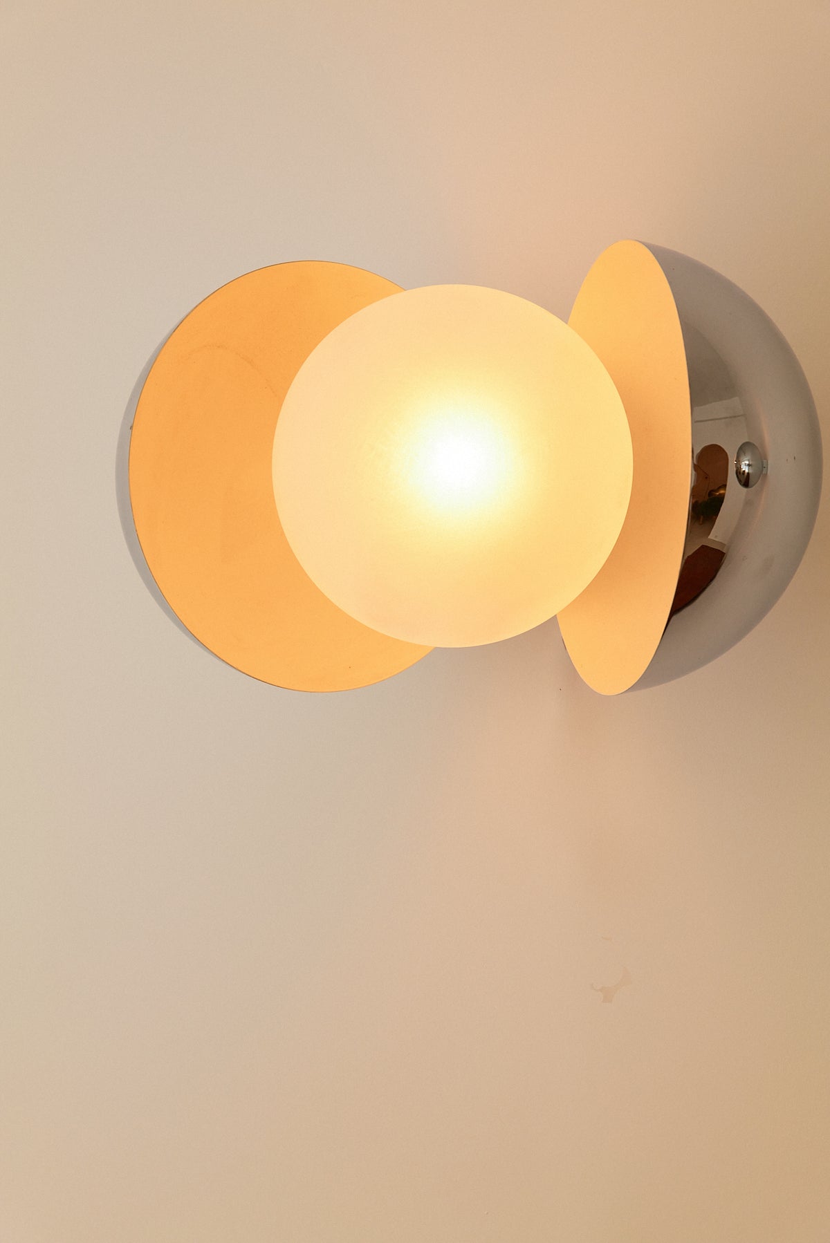 Gian Emilio, Piero & Anna Monti Diaframma polished steel and glass wall sconce, nearer view of the lit glass globe in the opening