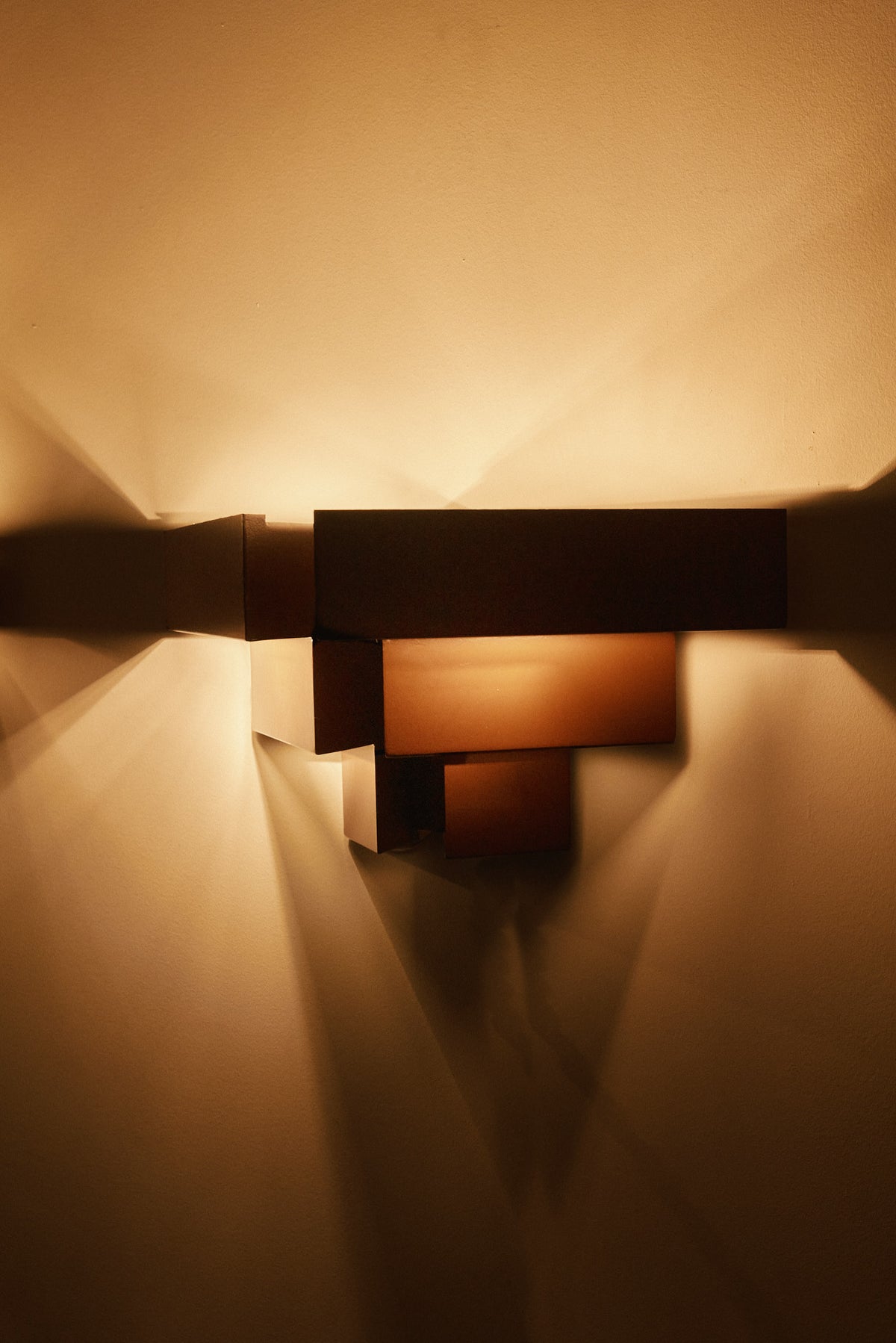 Stepped plate wall sconces, single sconce lit, close front view