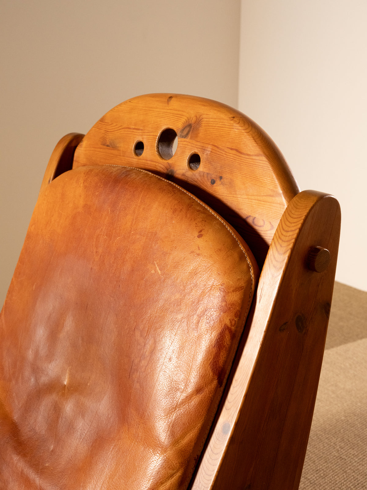 Wasa Furniture pine and patinated leather rocking chair, close view of the round holes in the arched back