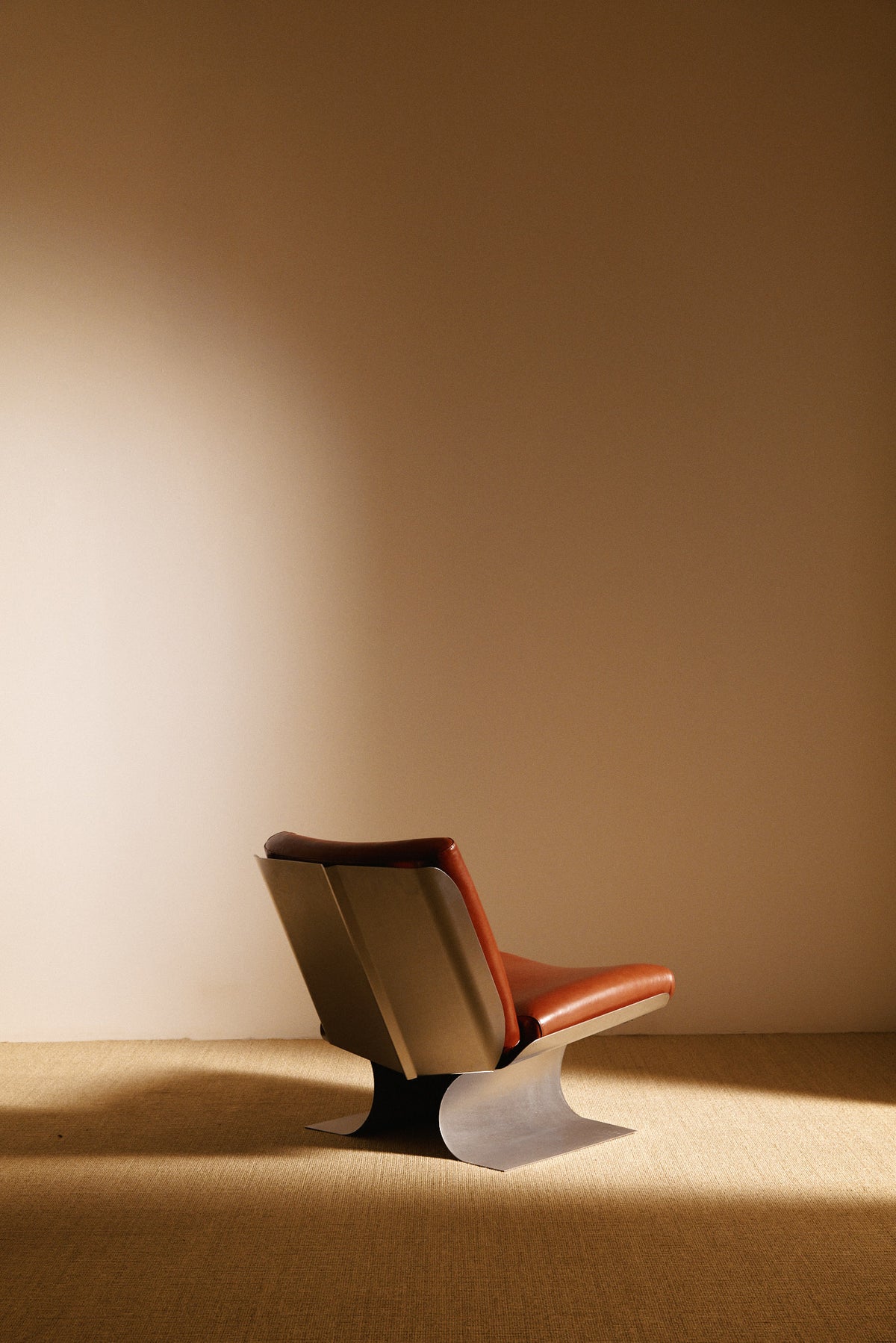 Xavier Féal cognac leather lounge chairs, single chair, rear angled view showing the steel back